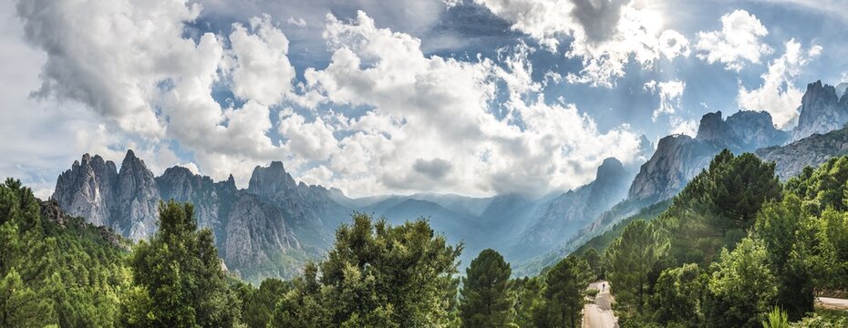 Panoramic, road through a valley with cliffs in clouds, Col de Bavella, Bavella Massif, Corsica, France