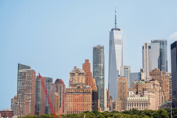 Fototapeta premium New york, usa august 16,2024. One world trade center rises over manhattans financial district skyline under a bright blue summer sky, modern glass tower scene