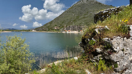 Fort Lesendro ruins overlooking Shkodra Lake with spring vegetation and sky © Friedbert