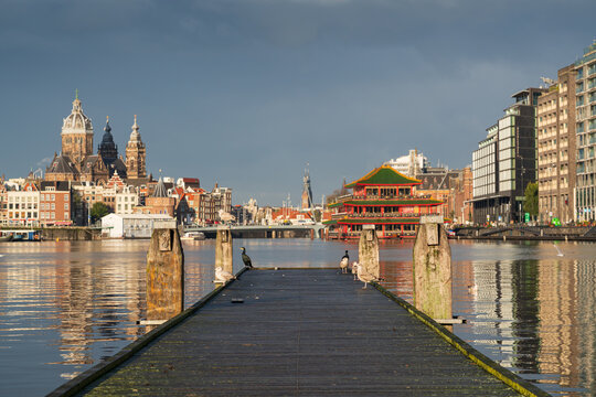 Amsterdam city skyline, featuring the Basilica of Saint Nicholas and the Sea Palace floating restaurant.