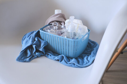 Baby hygiene and wellness essentials neatly arranged in a blue basket on a chair