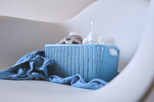 Baby essentials in a blue basket for newborn health and hygiene
