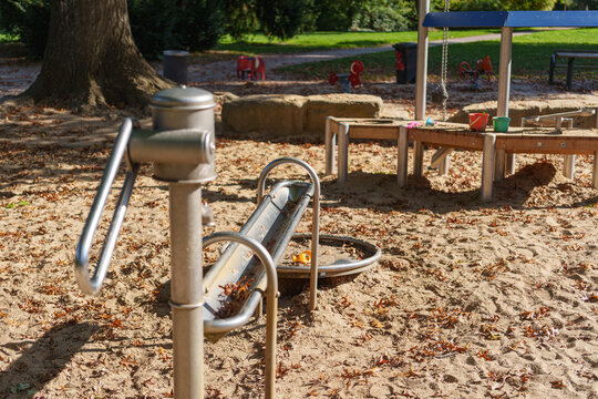Children playground sand area with metal slide and water play equipment
