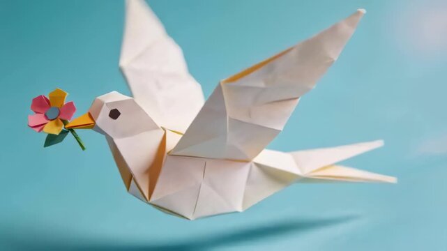 Gliding origami dove holding paper flower in blue studio, camera tracking forward suggesting flight