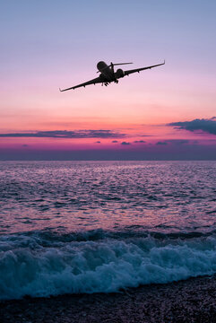 Corporate airplane take off over the sea against the backdrop of scenic sunrise sky