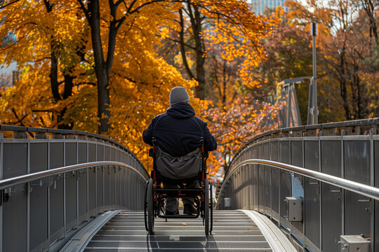 A man in a wheelchair is crossing a bridge