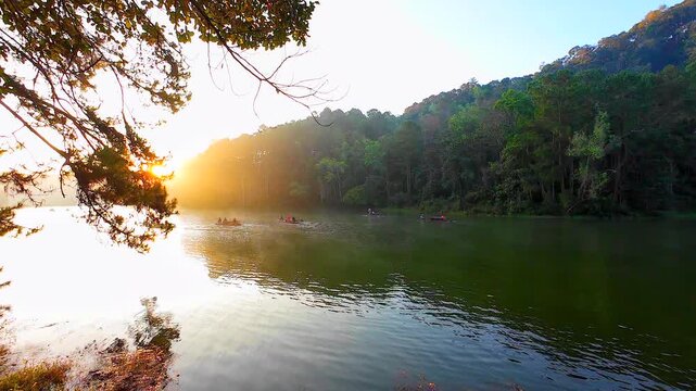 Thai and foreign tourists enjoy bamboo rafting on Pang Ung Lake, a tour of Pang Ung National Park, also known as Baan Rak Thai or the Switzerland of Thailand, in Mae Hong Son, Thailand.