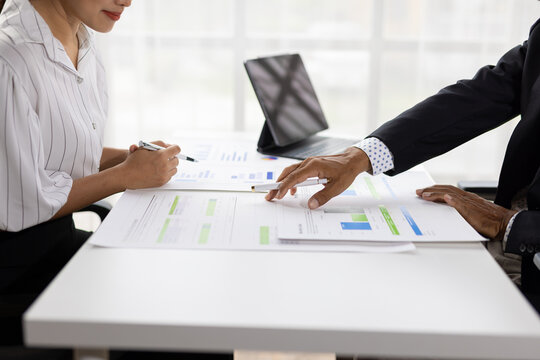 Professionals analyzing financial reports during business meeting.