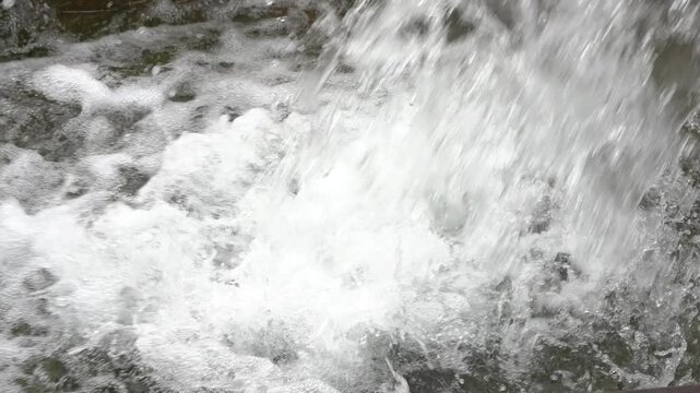 Powerful rushing water stream creating bubbles and foam
