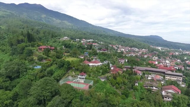 Aerial 4K view of a villa on the hillside of Puncak Tretes and the lush mountain landscape of East Java, Indonesia.