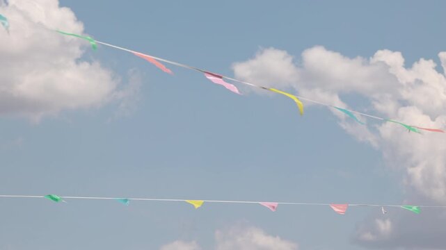 Crossing lines of colorful pennant flags fluttering in windy sky