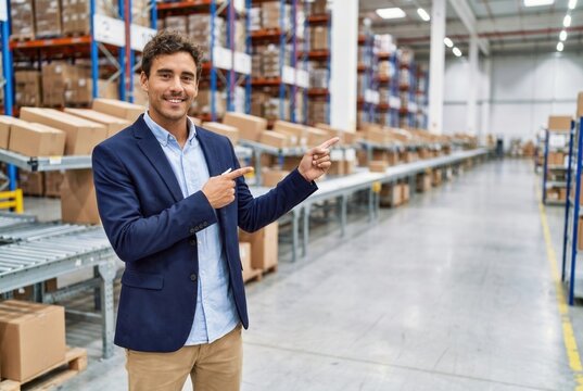 Warehouse manager pointing, showing logistics and distribution operations with a smile