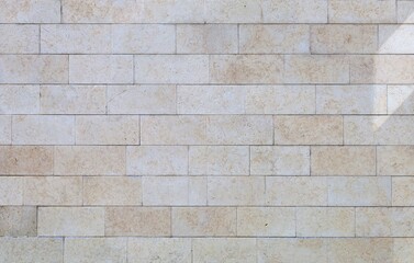 Fototapeta premium Off-white and beige travertine wall made of&nbsp; large rectangle tiles. Background and texture. Full frame.