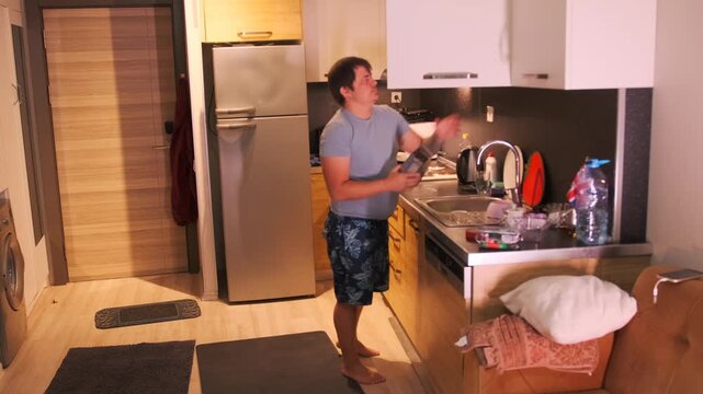Man placing kitchen graters into cabinet in modern kitchen, organizing cooking tools after use, everyday domestic routine, maintaining order and cleanliness, indoor lifestyle and home organization