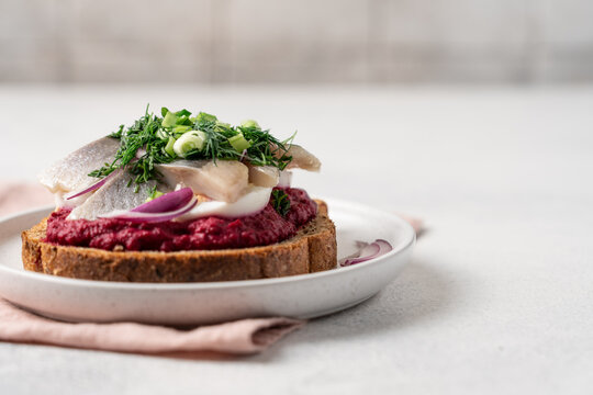 Open sandwich with herring beetroot mousse egg dill and green onion, traditional Scandinavian cuisine appetizer concept
