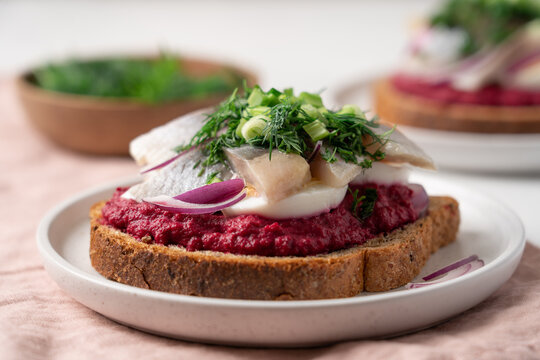 Open sandwich with herring beetroot mousse egg dill and green onion, traditional Scandinavian cuisine appetizer concept
