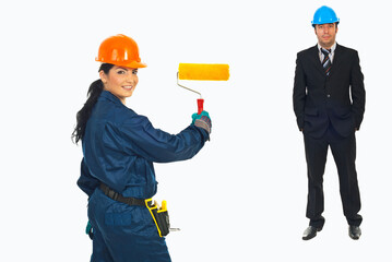 Fototapeta premium Woman holds paint roller, smiling at viewer