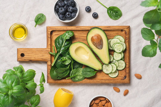 Avocado, spinach, almonds, cucumber and blueberries ingredients for healthy summer salad top view