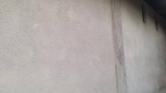 Smooth grey concrete wall surface moving slowly past the camera in a cinematic motion sequence showcasing industrial textures and minimalist architectural design elements for modern construction proje