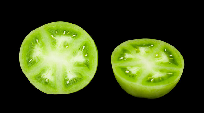 Green tomatoes isolated on a black background.