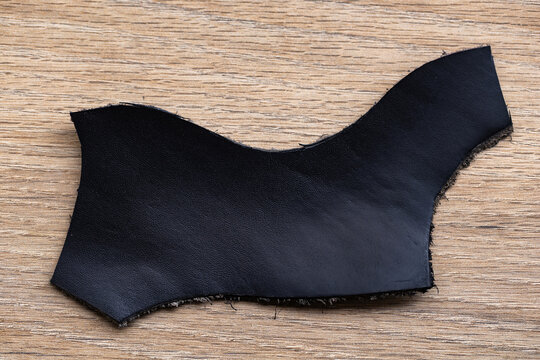 Black Leather Offcut on Textured Surface &ndash; Natural Material Scrap Close-Up