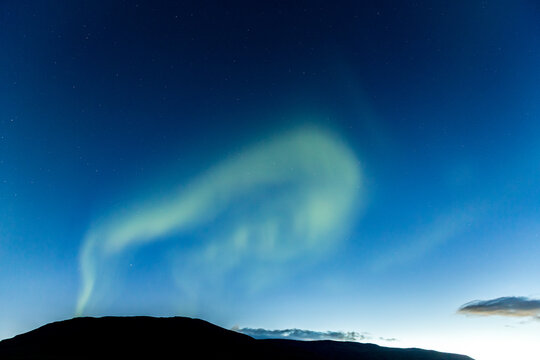 Arafed view of a mountain with a sky and a green aurora, Hvitserkur, Northern Iceland, long exposure motion blur