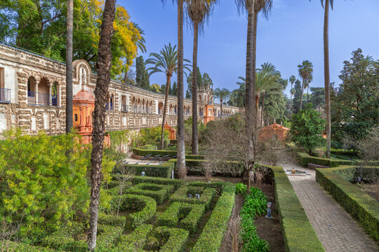 Gallery of Grutescos in Royal Alcazar gardens of Seville Spain. Renaissance architecture and green park under blue sky