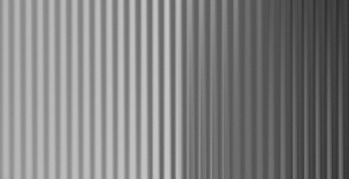 Vertical lines stretch across the frame. Soft tones shift from light to dark. Texture suggests metal or fabric. No people, no animals, no plants. Ideal for modern design or abstract backgrounds