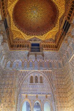 Ornate Mudejar ceiling and carved wall in Royal Alcazar of Seville Spain. Ancient Islamic geometric patterns in stone