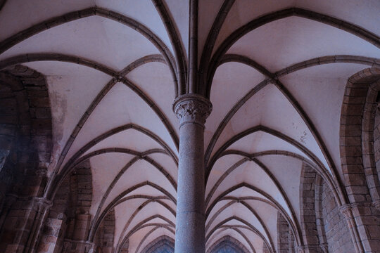 Mont Saint-Michel, France: Dramatic low angle view of vaulted ceilings and ribbed arches in the medieval scriptorium of the abbey. Gothic architecture.