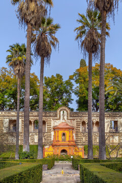 Gallery of Grutescos in Royal Alcazar gardens of Seville Spain. Renaissance architecture and green park under blue sky