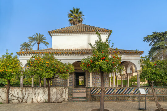 Pavilion of Charles V in Royal Alcazar gardens of Seville Spain. Historic architecture with ceramic tiles under blue sky