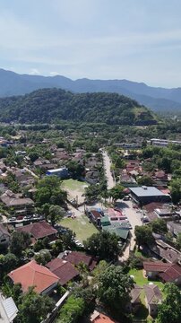 Imagem a&eacute;rea de bairro residencial pr&oacute;ximo &agrave; Praia da Barra do Sahy mostrando casas cercadas por vegeta&ccedil;&atilde;o e relevo montanhoso no litoral norte paulista