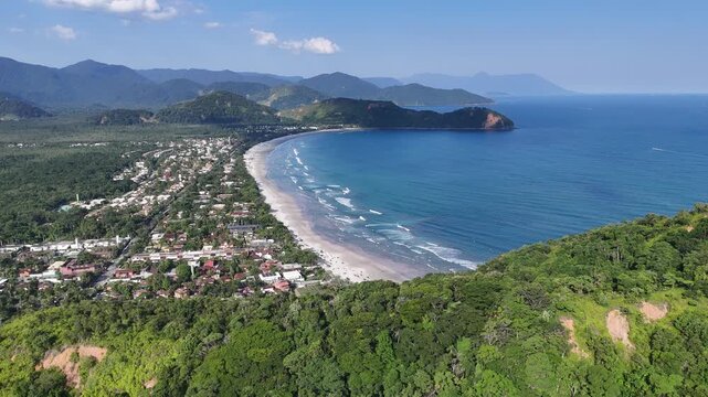 Vista a&eacute;rea da Praia da Baleia com mar azul, faixa de areia extensa e vegeta&ccedil;&atilde;o preservada, destacando turismo e natureza no litoral norte de S&atilde;o Paulo
