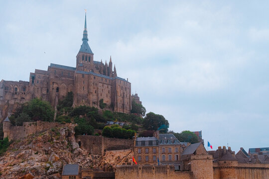 Mont Saint-Michel, France: Grand exterior view of the medieval abbey and fortified walls on the rocky island hill. Iconic Gothic landmark.