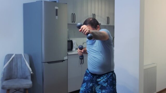Man performs shadow boxing with dumbbells at home, training arms and cardio endurance. Indoor fitness routine, strength workout, active lifestyle and home exercise training session