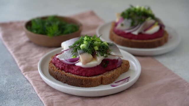 Close up view of open sandwich with herring beetroot mousse egg dill and green onion, traditional Scandinavian cuisine appetizer concept video