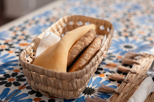 Moroccan breakfast bread basket on a vibrant zellige mosaic table, showcasing traditional cuisine and culture