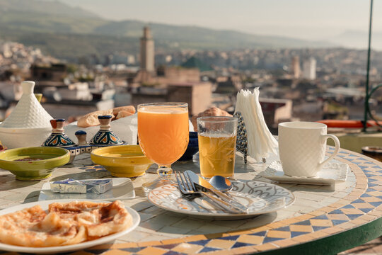 Moroccan breakfast on a rooftop terrace overlooking the ancient Fes Medina with traditional food and drinks