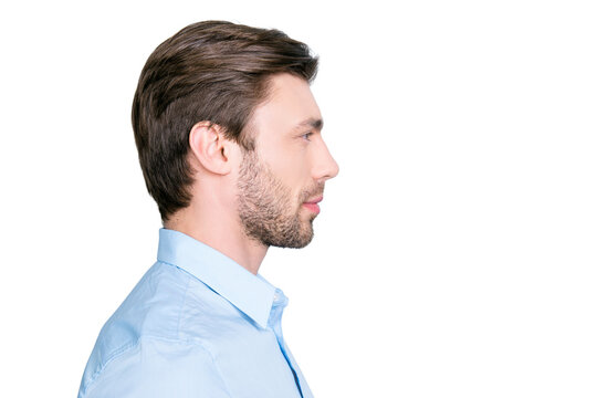 Close up side portrait of young bearded manager standing over grey background with copy space
