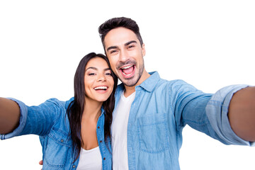 Naklejka premium Close up photo of lovely charming recently married wife and husband having honeymoon. They are happy, having fun and taking a selfie, isolated on grey abckground