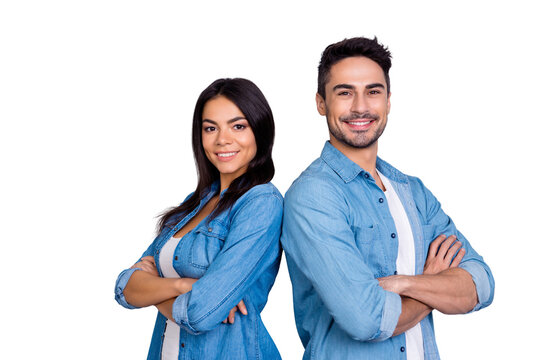 Concept of multiethnic cooperation and friendship. Attractive delightful hispanic woman in denim clothes and handsome causasian smiling man in jeans shirt are standing back to back against  background