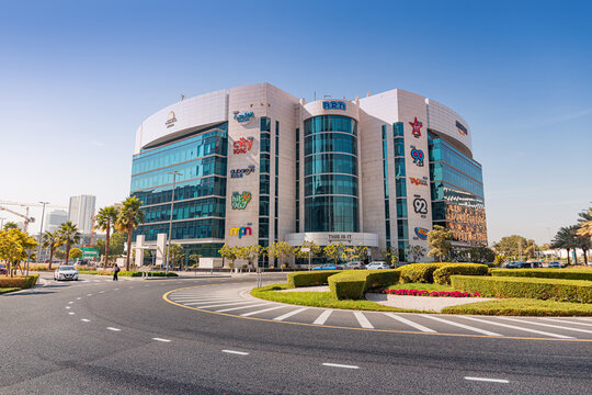 14 January 2026, Dubai, UAE: Iconic ARD broadcasting building in Media City showing various radio station logos, surrounded by roads and palm trees
