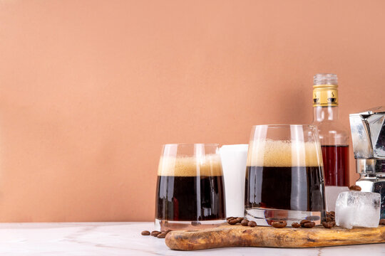 Trendy viral italian iced coffee drink caffee shakerato, cold summer whipped coffee with simple Liqueur and ice in tall glasses