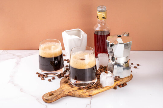 Trendy viral italian iced coffee drink caffee shakerato, cold summer whipped coffee with simple Liqueur and ice in tall glasses