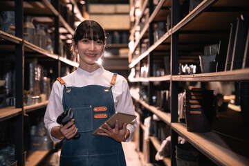 Smiling female worker in storage aisle holding scanner and tablet © chokniti