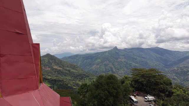 Toma a&eacute;rea cinematogr&aacute;fica (drone pull-away) que revela la torre de una iglesia colonial con un distintivo reloj y techo rojo. El plano se expande para mostrar el pintoresco pueblo de Vergara 