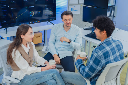 Diverse Tech Team Collaborating and Discussing Project Strategy During Coffee Break in Modern AI Office