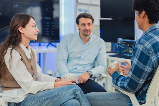 Diverse Tech Team Collaborating and Discussing Project Strategy During Coffee Break in Modern AI Office