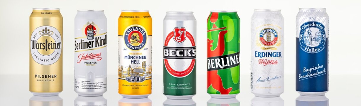 Studio lineup of German beer cans featuring brands such as Warsteiner, Berliner Kindl, Paulaner, Beck&rsquo;s and Erdinger isolated on white background.